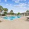 Large sparkling blue pool with a large pool deck and lounge chairs